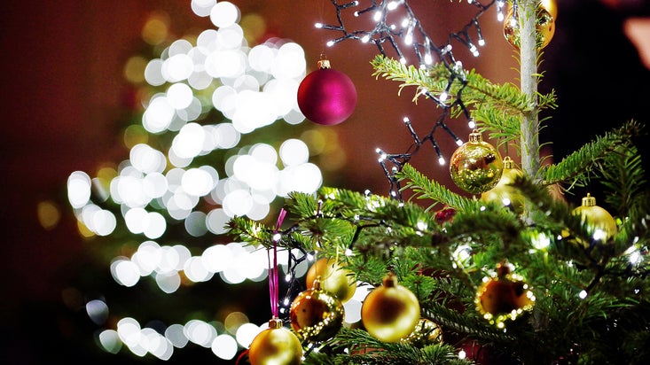A close-up image of a Christmas tree with lights and baubles at Uppark, with more lights out of focus in the background